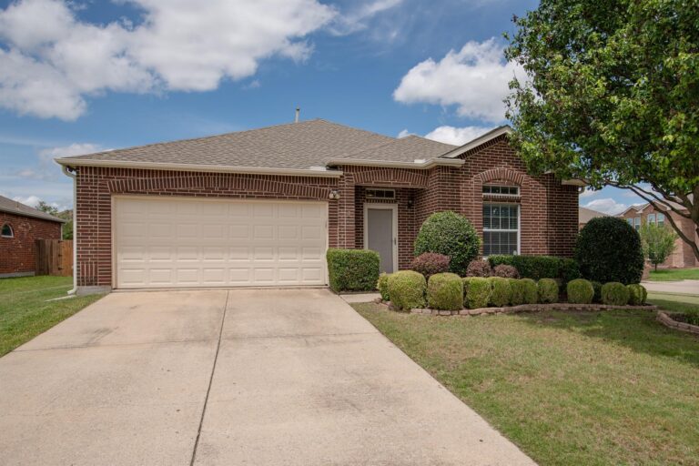 Front exterior of a single-story brick and stone home at 1300 Shelby Ct, Wylie, Texas, featuring a manicured lawn, young tree, and welcoming entrance with a covered porch.