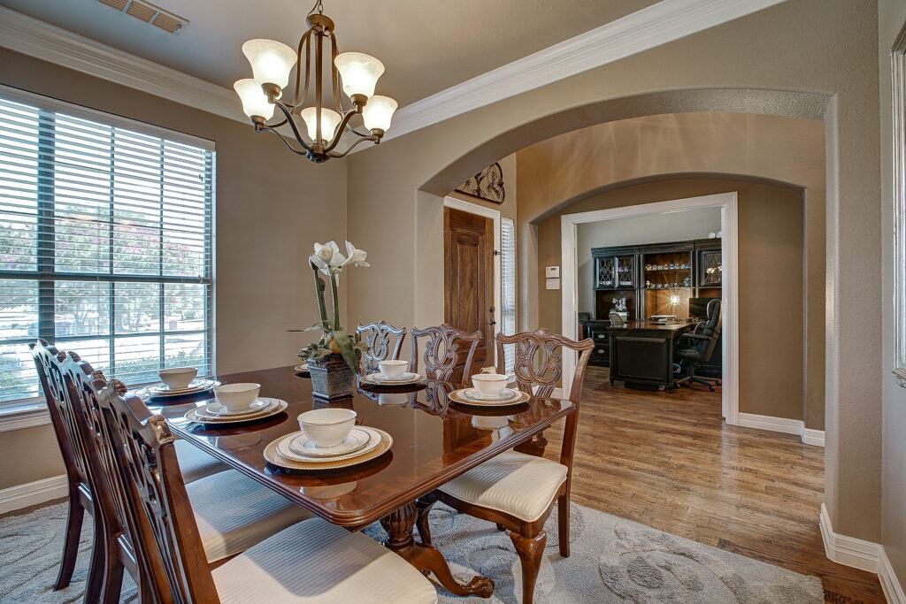 Dining table with view into home office through arched doorway