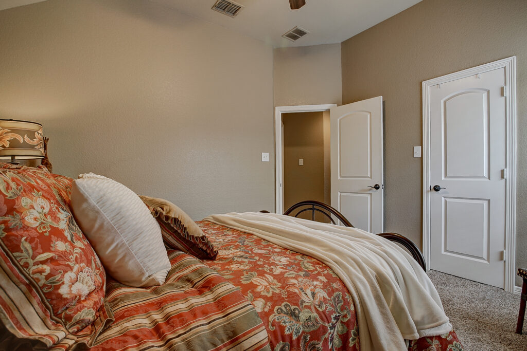 Side angle of guest bedroom showing closet doors and hallway entrance