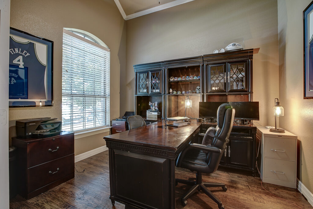 Home office with large wooden desk and built-in shelving