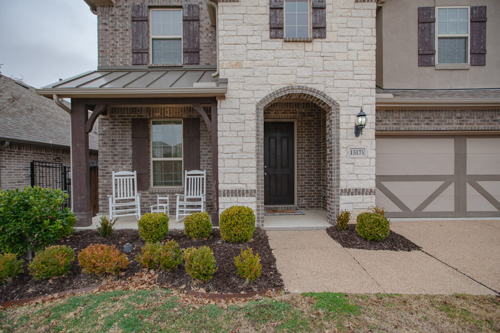 Front porch with stone and brick exterior and rocking chairs