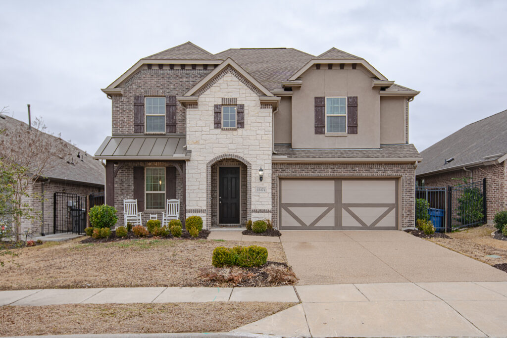 Full front view of two-story home with brick and stone exterior
