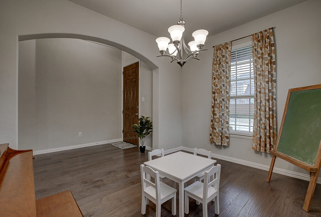 Bright and open front living room with kid-sized table under modern chandelier