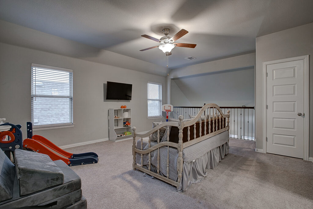 Upstairs game room with TV, slide, and cozy daybed