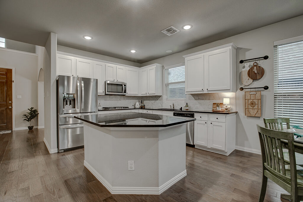 Modern kitchen with white cabinets and stainless steel appliances