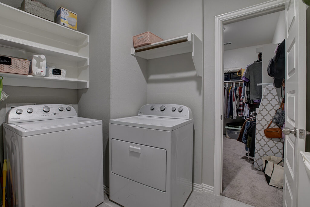 Laundry room with washer, dryer, and shelves