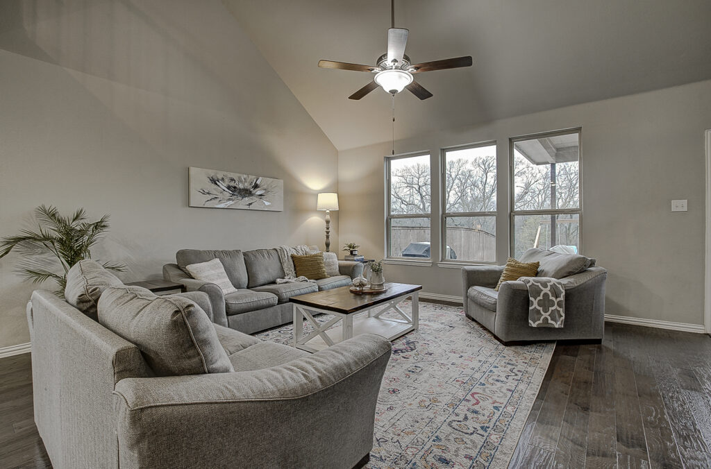 Living room with vaulted ceiling and backyard views