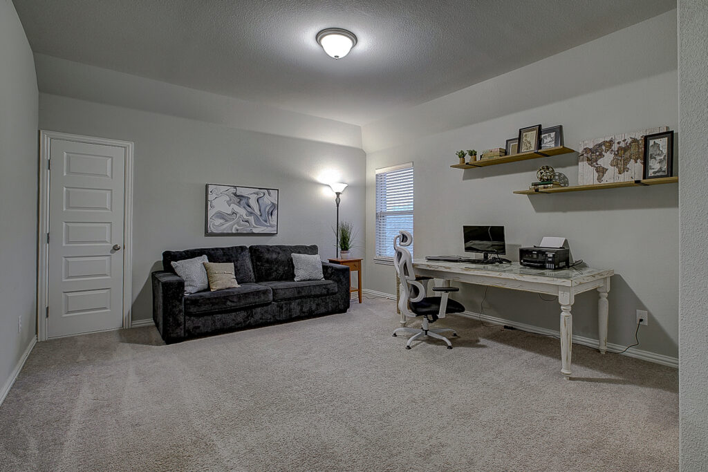 Oversized bedroom with carpet, window, and home office furniture