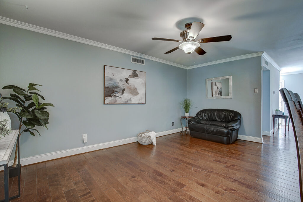 Main living room at 5302 Saddleback Rd Garland TX with wood flooring, crown molding, ceiling fan, and open layout