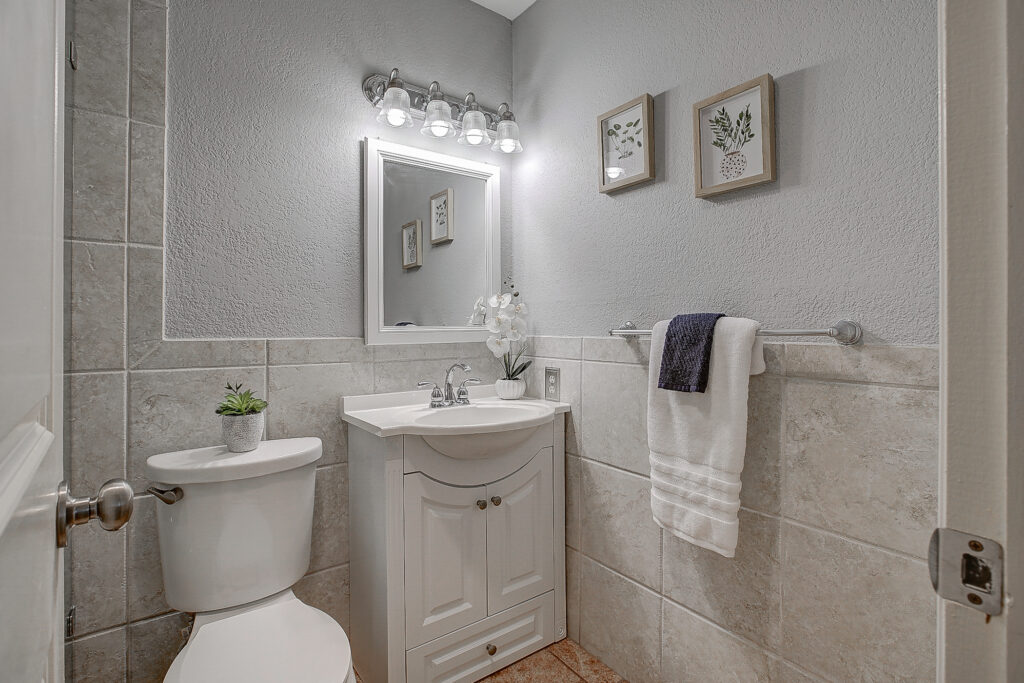 Bathroom at 5302 Saddleback Rd Garland TX with vanity, mirror, lighting fixture, and tile walls
