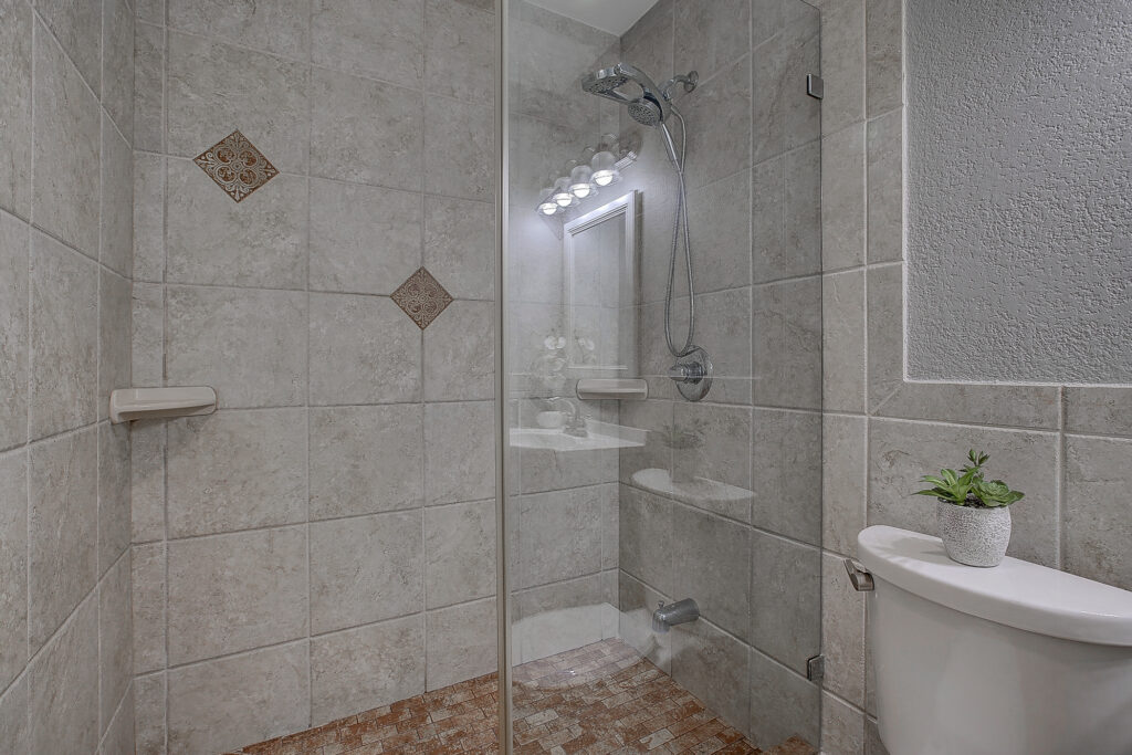 Bathroom shower at 5302 Saddleback Rd Garland TX with tiled walls, glass enclosure, and shower fixture