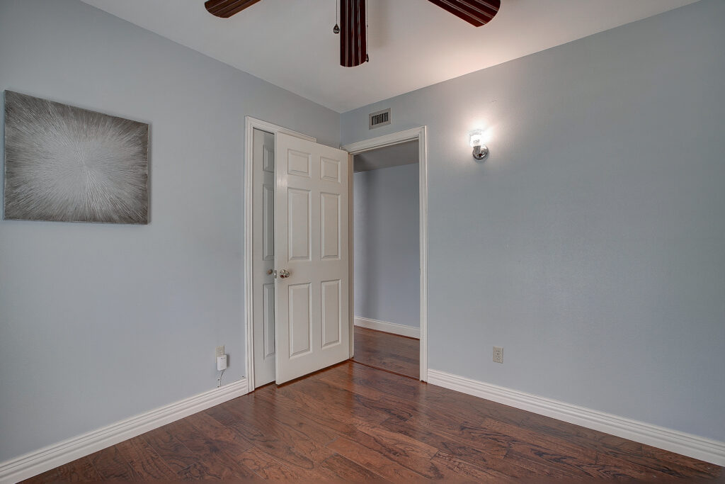 Secondary bedroom at 5302 Saddleback Rd Garland TX with wood floors, and ceiling fan.