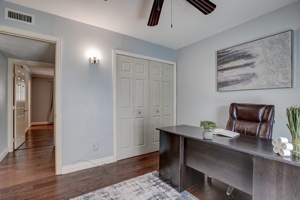 Bedroom or office at 5302 Saddleback Rd Garland TX with closet, wood floors, and ceiling fan