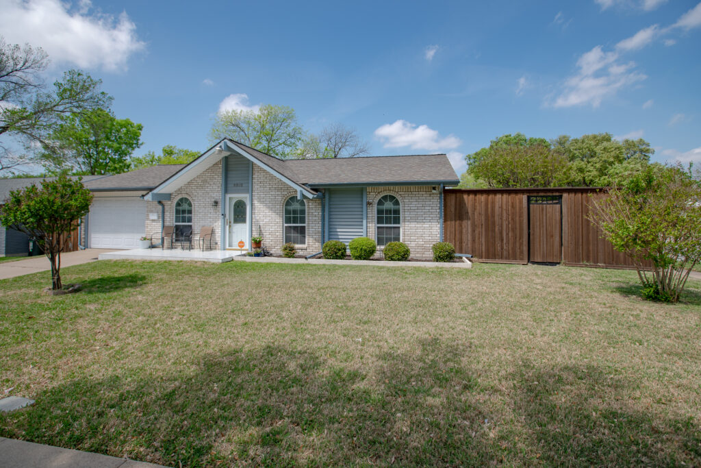 Front exterior of 5302 Saddleback Rd Garland TX with garage, extended driveway, and fenced side yard