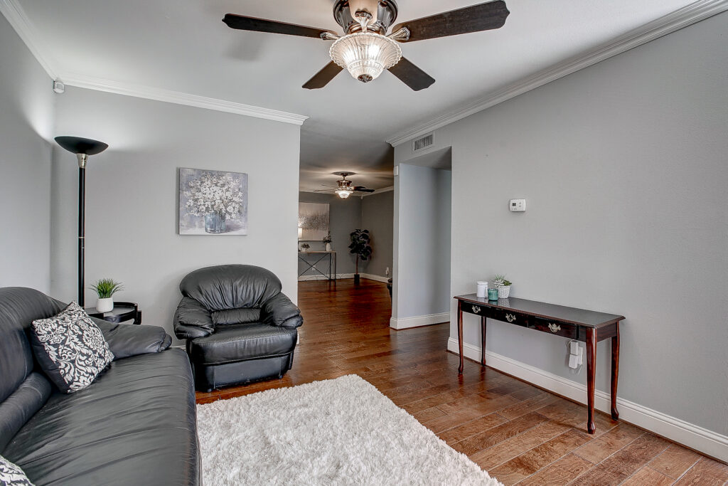 Living room at 5302 Saddleback Rd Garland TX with wood floors, seating area, and open layout to additional living space