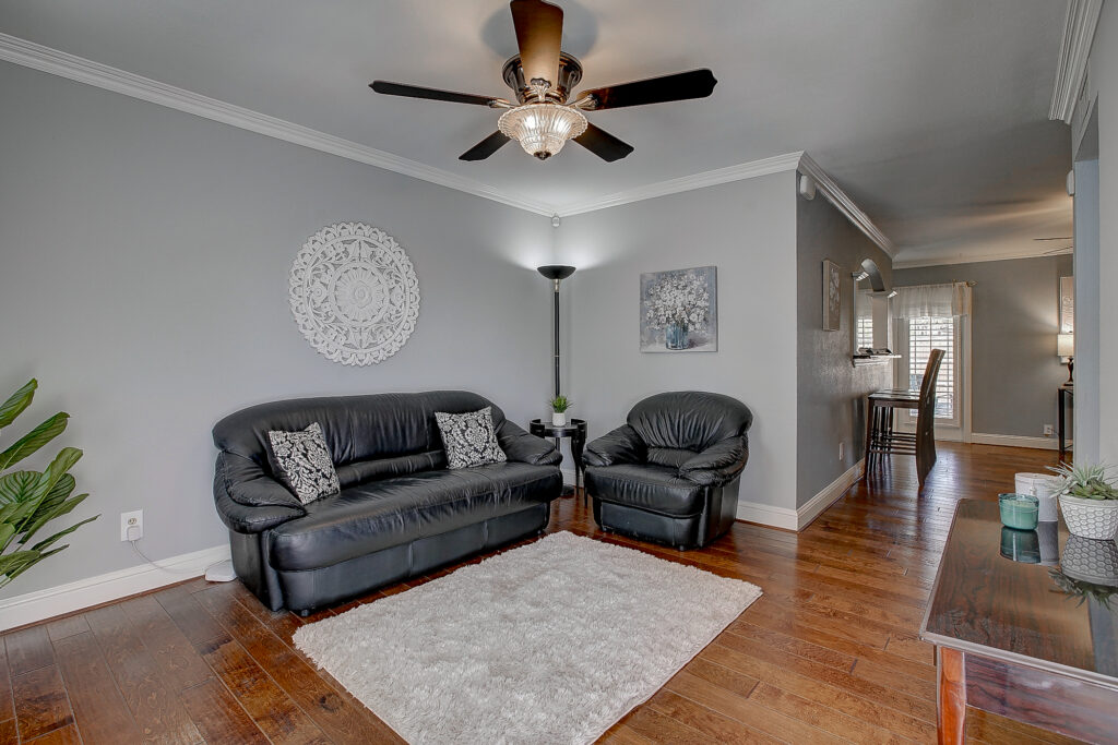 Living room at 5302 Saddleback Rd Garland TX with wood floors, seating area, and open flow toward dining space